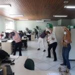 Colaboradores realizam ginástica laboral promovida pela Federação Rio