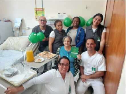 Equipe de enfermagem em momento comemorativo com a cliente Maria Eclea